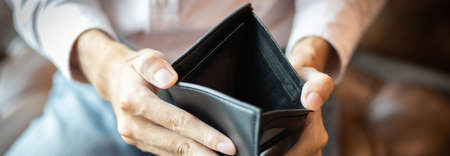 Young man had no money in his wallet, save money concept.の写真素材