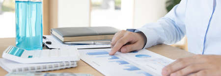 Financial business people are analyzing and examining Revenue - expense of real estate of the company, Detention periods or social distances, Alcohol bottle, Financial and tax systems concept.の写真素材