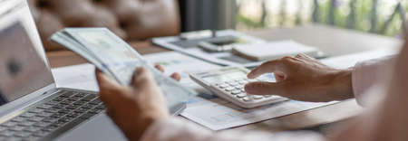 Men are calculating using graphs and calculators to make family expenses in order to save money and be used in the future, Financial savings and income tax calculation concept.の写真素材