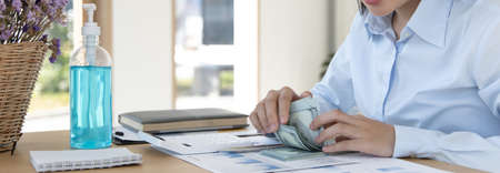 Counting money, businesswomen have analyzed between cash and credit card which is consistent and convenient to spend in the present day.の写真素材
