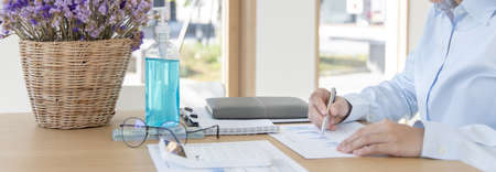 Financial business people are analyzing and examining Revenue - expense of real estate of the company, Detention periods or social distances, Alcohol bottle, Financial and tax systems concept.の写真素材