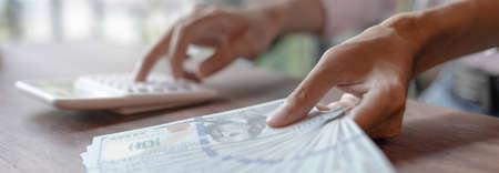 Female housekeepers are calculating using graphs and calculators to make family expenses in order to save money and be used in the future, Financial savings and income tax calculation concept.の写真素材