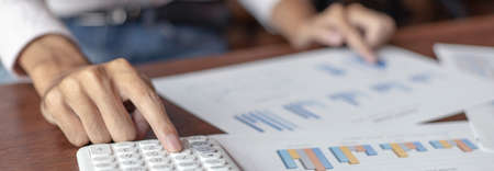 Business men are calculating real estate investment expenditures and analyzing the company's finances in line with the global economy, Analysis of financial accounting and real estate investment concept.の写真素材