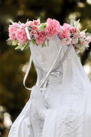 Statue of Mary with pink wreath