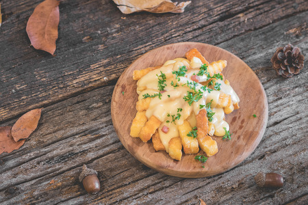french fries with cheese on wooden