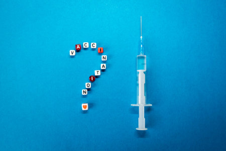 Question mark made of vaccination word and a syringe on blue background. Pros and cons, yes or no for  vaccine, concerns about   vaccine conceptの写真素材