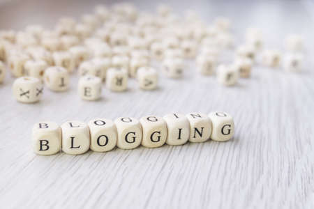 Word Blogging made with block wooden letters cubes next to a pile of other letters over the wooden board surface. Content marketing, blogging conceptの写真素材