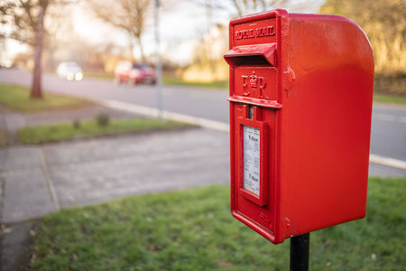SWANSEA, WALES, UK - FEBRUARY 25, 2021: Traditional British red Royal Mail mailbox for letters in a Street in Wales, United Kingdomのeditorial素材