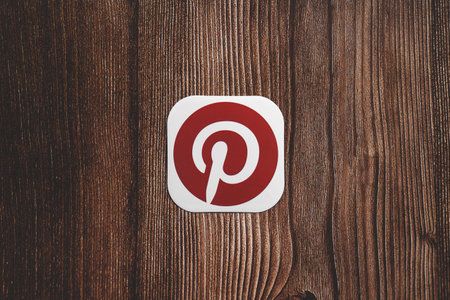 Pinterest red round logo printed on paper centrally placed on wooden backgroundのeditorial素材