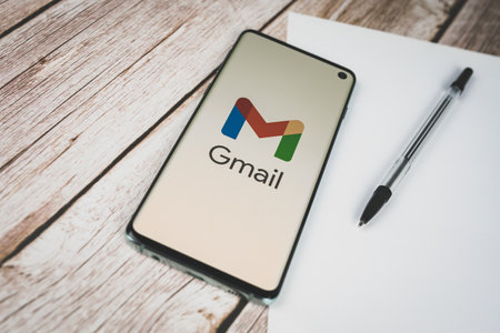 Smartphone with new 2020 Google Gmail logo on desk with pen and paper