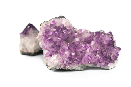 Two raw natural purple amethysts cluster crystals isolated on white background. Big sparkle druse and small gemstone.の写真素材