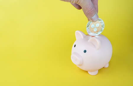 Man putting Ripples XRP coin into a piggybank