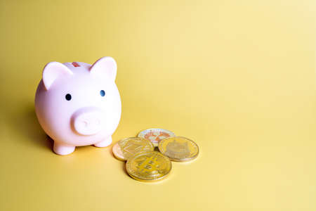 Piggy bank and Bitcoin, XRP, Dogecoin, Ethereum cryptocurrency coins with copy spaceの写真素材