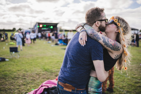 BIRMINGHAM, THE UNITED KINGDOM - AUGUST 22, 2020: Open air electronic music festival with social distancing measures near Birmingham, the UK. Couple kissing in front of the stageのeditorial素材