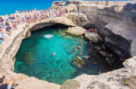 Lecce, Italy - September 12, 2017: Grotta Della Poesia or Cave of Poetry. People swimming in a natural sea cave in Roca Vecchia on the Adriatic coastline, Apulia, Italy.のeditorial素材