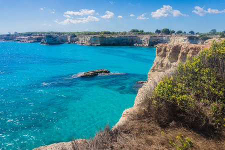 Torre Sant Andrea, Salento sea coast, Apulia, Italy. Faraglioni Melendugno. Beautiful rocky Seascape with cliffs in Puglia. Blue turquoise saturated clear water. Bright Summer day. No people.の写真素材