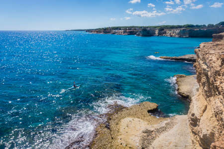 Torre Sant Andrea, Salento sea coast, Apulia, Italy. Faraglioni Melendugno. Beautiful rocky Seascape with cliffs in Puglia. Kayaking. Blue turquoise saturated clear water.の写真素材