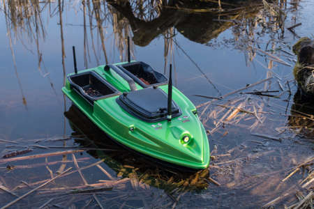Bait Boat on water. Wireless remote control green fishing feeder, fish finder boat.の写真素材