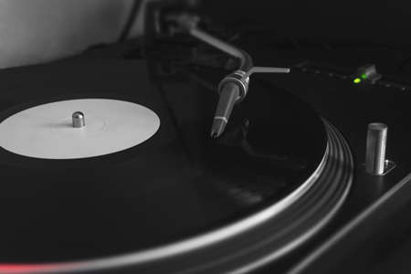 Turntable record player playing blank vinyl with stylus needle, close-up, selective focus. Black and white with selective colors.の写真素材
