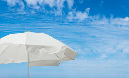 White beach umbrella against blue sky with copy space.の写真素材