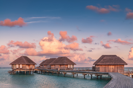 Wonderful golden hour at tropical beach resort with beautiful cloudy sky in Maldives.の写真素材