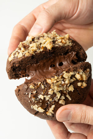 Chocolate cookies with chocolate cream and nuts on a white background.の写真素材