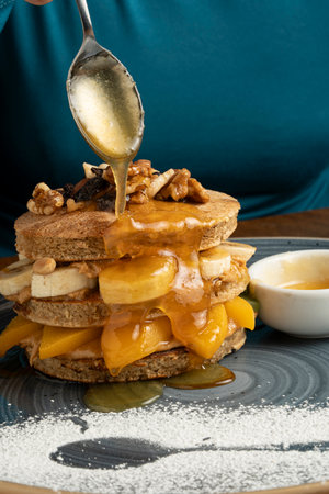 Waffles with caramel sauce and peaches on a wooden background.の写真素材