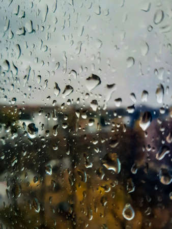 Raindrops on the window, the city in the background.