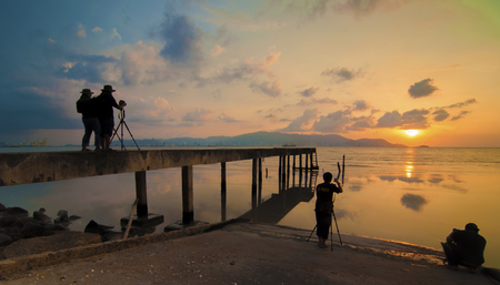An old jetty with silhouette of people