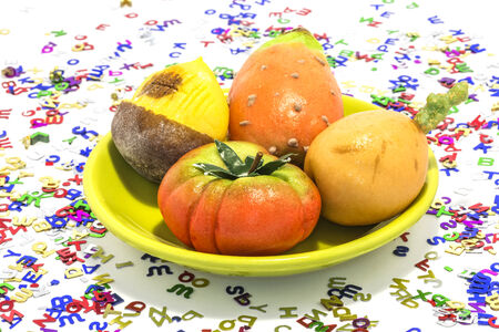 Marzipan sweets, chestnut, prickly pear, tomato, medlar, surrounded by so many letters の写真素材