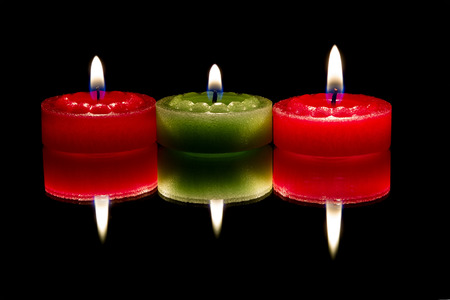 Three candles, reflected, on dark backgroundの写真素材
