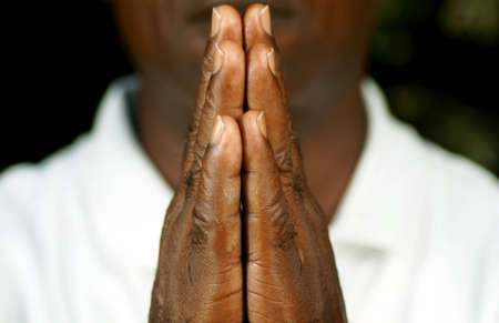 fingers of afro man in prayer 