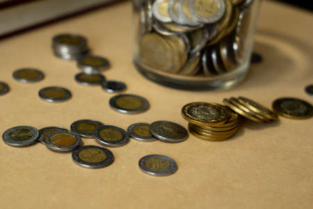 jar of glass full of mexican coins and money droppedの写真素材