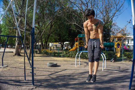 Man doing exercise calisthenics, bent arm straddle planche in park