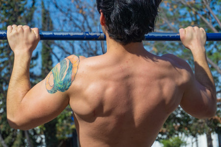 Man doing exercise calisthenics, bent arm straddle planche in park