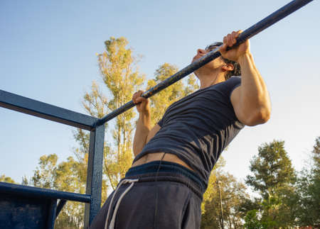 Man doing exercise calisthenics, bent arm straddle planche in park