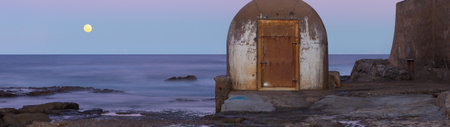 Panoramic view of an old house by the sea at night