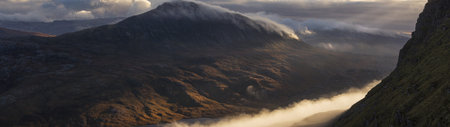 A panoramic view of a foggy and misty valley in the Scottish Highlandsの写真素材