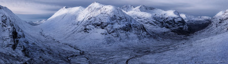 Panoramic view of snow capped mountain range in Scotland, UKの写真素材
