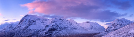 Panoramic view of the snowy mountains in Scotland at sunset.の写真素材