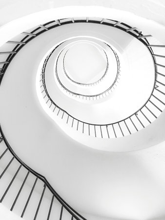 White spiral staircase in a modern building, perspective view from the top