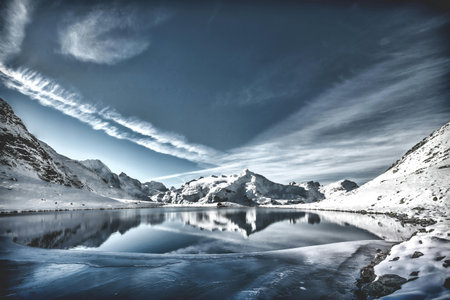 Beautiful winter landscape with frozen lake and snowy mountains. Toned.の写真素材