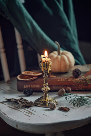 Vintage candlestick with candle and pumpkins on the tableの写真素材