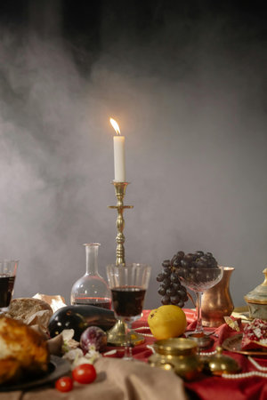 Table with wine, bread and candlestick on a dark backgroundの写真素材