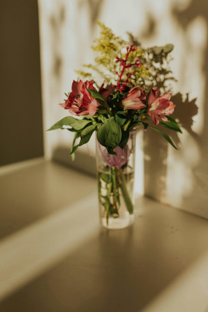 Bouquet of flowers in a vase on the windowsillの写真素材
