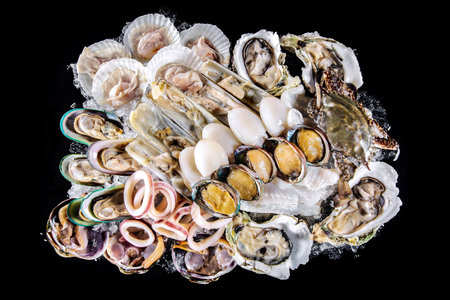 Fresh oysters on black background. Top view. Seafood.の写真素材