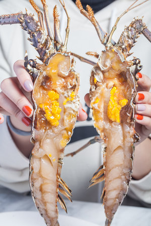 Woman's hands holding fresh sea prawns, close-upの写真素材