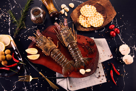 Lobster on a cutting board with spices on a black backgroundの写真素材
