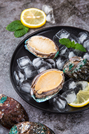 Fresh oysters with ice and lemon on a dark background. Selective focus.