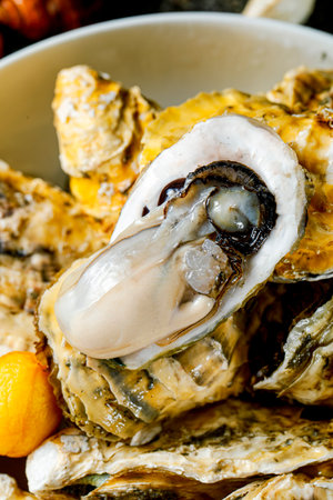 Fresh oysters in shell on white plate. Selective focus.の写真素材
